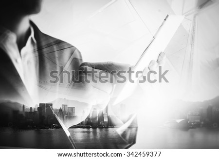 BW double exposure of city and business man using digital tablet.