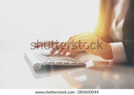 Closeup photo of female hands typing text on a wireless keyboard. Business woman working at the office. Visual effects, white background
