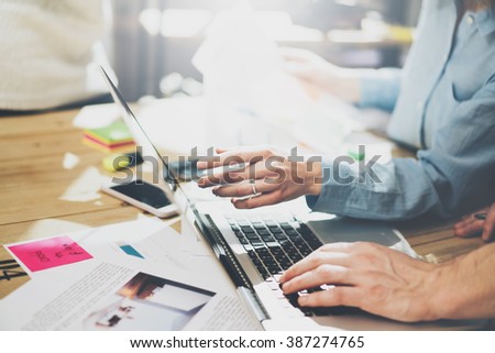 Marketing analysis team meeting concept. Young businessman crew working with new startup project in modern studio. Generic design notebook on wood table. Horizontal, film effect