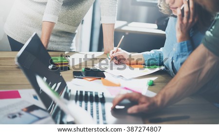 Accounting business meeting concept. Photo young businessman crew working with new startup project in modern loft. Generic design notebook on wood table, talking smartphone. Horizontal, film effect