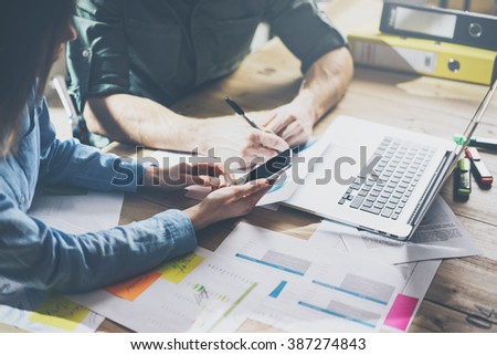 Marketing analysis team meeting concept. Young businessman crew working with new startup project in modern loft. Generic design notebook on wood table. Horizontal, film effect