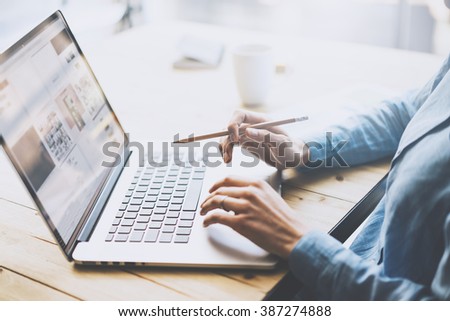 Student work concept. Young girl working university project with generic design laptop.  Notebook wooden table, texting message. Blurred background, film effect. Horizontal