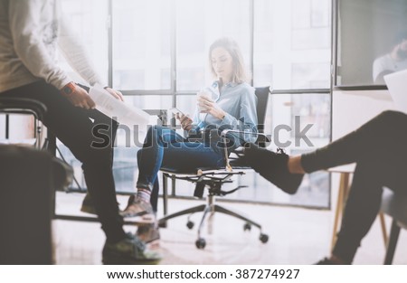 Teamwork concept, brainstorming. Businessman crew working with new startup project in modern loft. Woman holding smartphone hands. Horizontal, film effect