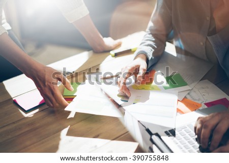 Team partnership. Photo young business managers  working with new startup project in office. Analyze document, plans. Generic design notebook on wood table, papers, documents. Horizontal, blurred