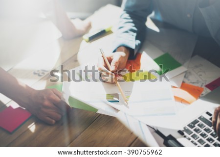 Team account manager project.Photo young business managers working with new startup in modern loft.Analyze reports,plans. Generic design notebook on wood table, papers, documents. Horizontal, blurred