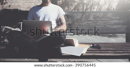 Photo man sitting city park bench and using laptop wireless internet. Studying at the University, working new project. Using book, generic design computer. Wide
