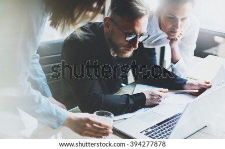 Business team work process. Photo young professionals crew working with new startup project. Project managers meeting. Presentation business plans laptop. Blurred background, film effect. Horizontal