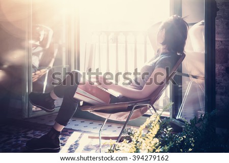 Photo young girl sitting leather armchair in modern building and use laptop wireless internet. Studying at the University, working, preparing exams. Using book, notebook. Sunny day. Horizontal