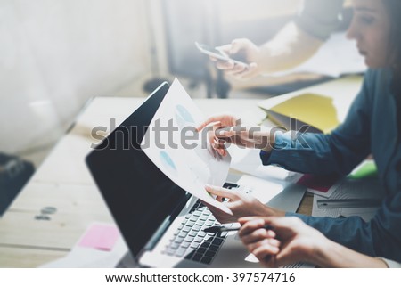 Team account manager project work.Business managers working with new startup in modern loft.Analyze reports,plans. Notebook on wood table, papers, documents, statistics. Horizontal, blurred