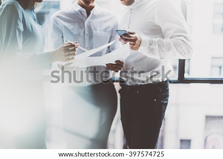 Business team meeting,work process.Photo professional crew working with new startup project.Project managers near window.Analyze business plans, smartphone hands. Blurred, film effect.Horizontal