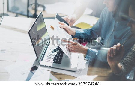 Team account manager project work.Business managers working with new startup in modern loft.Analyze reports,plans. Notebook on wood table, papers, documents, statistics. Horizontal, film effect