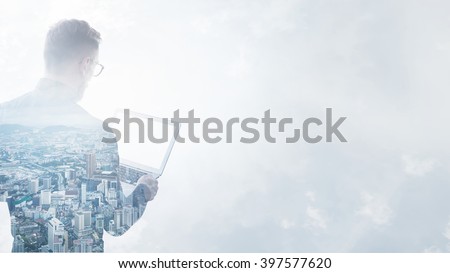 Double exposure young bearded businessman wearing black shirt holding contemporary notebook hands.Isolated white,modern city background.Blank screen ready for your business message.Wide mockup