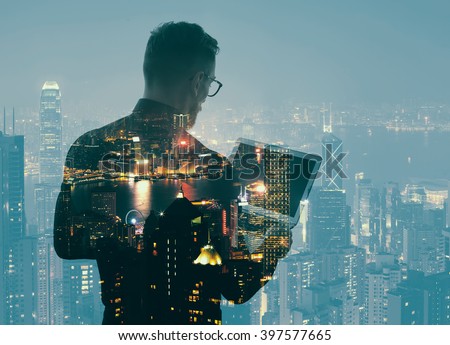 Double exposure young bearded businessman wearing black shirt and holding modern notebook hands. Panoramic view contemporary night city background. Horizontal mockup, bokeh, color