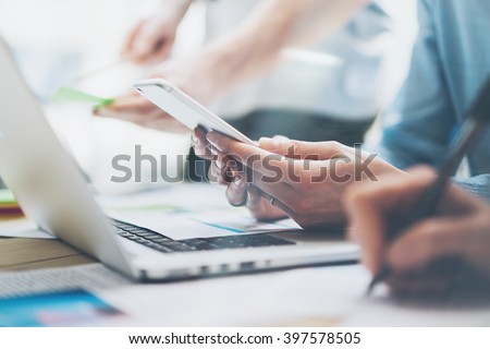 Closeup photo team job. Young business crew working with new startup project. Notebook on wood table,smartphone hands.Analyze plans, keyboard. Blurred background, film effect. Horizontal