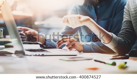 Business meeting time. Photo young account managers crew working with new startup project. Notebook on wood table. Idea presentation, analyze plans. Wide,film effect