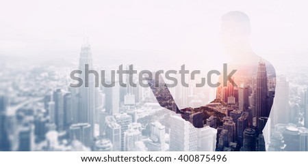 Double exposure photo bearded businessman wearing black shirt and glasses.Banker using contemporary notebook hands,work online banking.Panoramic view modern skyscraper city background.Soft light