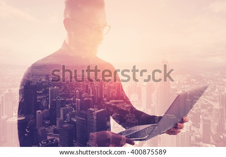 Double exposure businessman wearing black shirt and glasses.Banker holding contemporary notebook hands.Using work online banking system. Modern city sunset background. Horizontal mockup