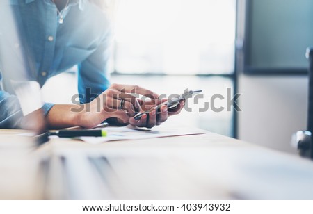 Business process photo. Account manager using mobile phone. Typing contemporary smartphone screen. Horizontal. Film effect. Blurred background