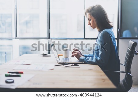 Working process modern office. Young finance manager working wood table with new business startup. Typing contemporary laptop. Horizontal. Film effect. Blurred background