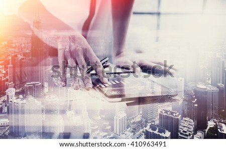 Double exposure photo.Female hand touching modern tablet.Investment manager working new private banking project office.Using electronic device.City skyscrapers background,film and bokeh effect.