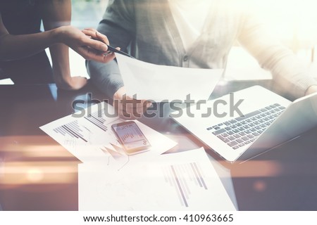 Business situation.Meeting of financial analysts.Photo female showing document.Man holding report, using laptop.Working process modern office,discussion startup. Horizontal. Film and bokeh effects
