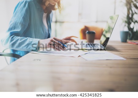 Photo Sales Manager Working Modern Office.Woman Use Generic Design Laptop and Holding Pencil.Account Department Work New Startup project.Process at Wood Table.Horizontal.Burred Background.Film effect