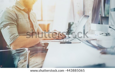 Bearded Hipster Working wood Table Laptop Modern Interior Design Loft Office.Man Work Coworking Studio,Use contemporary Notebook.Blurred Background.Creative Business Startup Idea.Flares,film effect