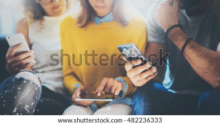 Closeup Group Adult Hipsters Friends Sitting Sofa Using Hands Modern Smartphone Tablet.Business Startup Friendship Teamwork Concept.People Working Together Project.Coworking Process Studio.Blurred