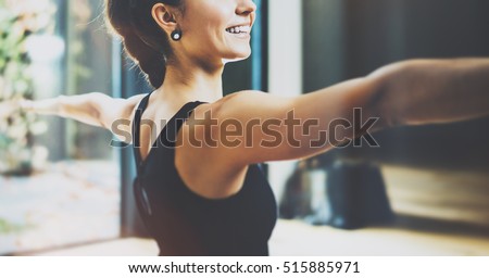 Close up view of gorgeous young woman practicing yoga indoor. Beautiful girl practice Warrior Light asana.Calmness and relax, female happiness concept.Horizontal, blurred background