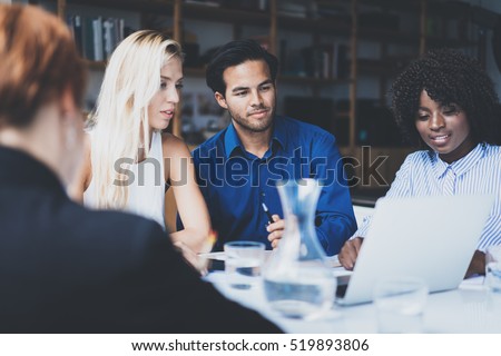 Young team of coworkers making great work discussion in modern office.Hispanic businessman talking with partners.Business people meeting concept.Horizontal, blurred background