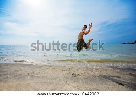 excited man jump up high happily by the beach