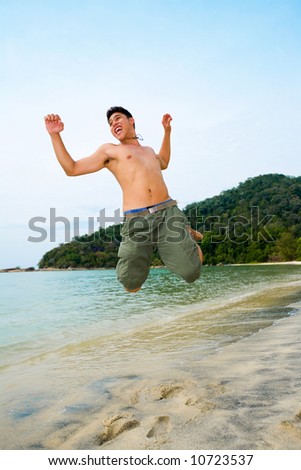 man jumping in excitement on the beach