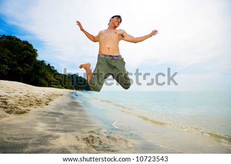 happy man jumping in excitement on the beach