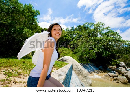 happy angel woman sitting on the edge by the sea