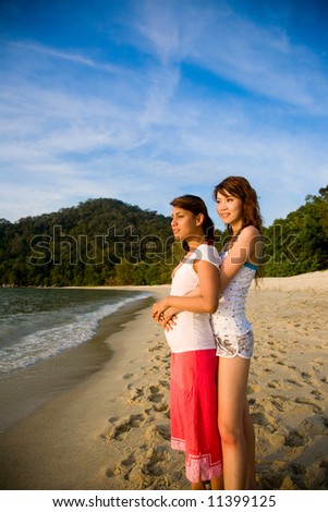 woman best friends hugging each other at the beach look on sunset