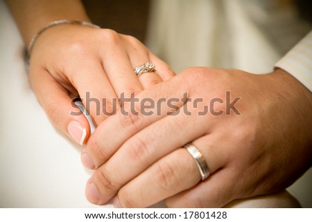 stock photo bride and groom holding hands with wedding rings on it