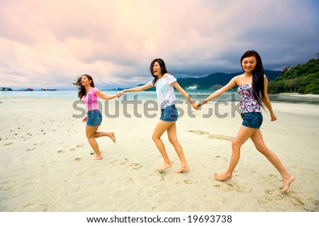 group of asian woman holding hand together at the beach