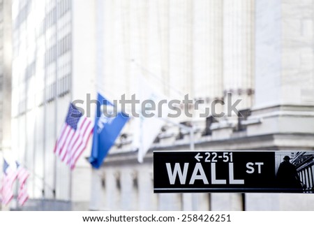 New York, NY, USA - January 18, 2013: A Wall Street street sign: The Exchange building was built in 1903. Wall Street is the home of the New York Stock Exchange, the world\'s largest stock exchange
