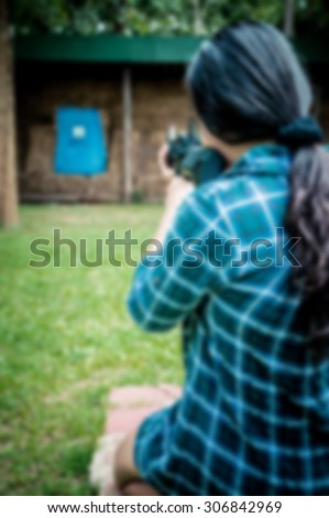 Blurred photo of a woman shooting at a target.