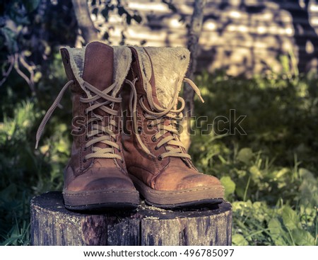 winter boots on a thick wooden stump dry