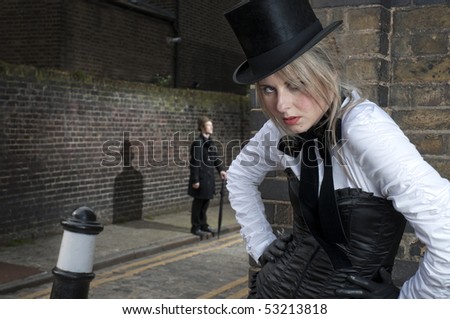 Street Fashion shot of woman in late victorian clothes with man in the background.