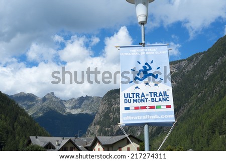TRIENT, SWITZERLAND - AUGUST 31: Ultra Trail du Mont Blanc banner and Fontanabran mountain in the background. The ultra-marathon takes on average 30 to 45 hours to complete. August 31, 2014 in Trient.