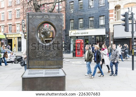 LONDON, UK - OCTOBER 26: Agatha Christie book shaped memorial with busy street in the background. The bronze memorial was unveiled on the 18 November 2012. October 26, 2014 in London.