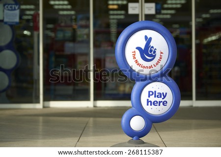 LONDON, UK - APRIL 07: Blue National lottery sign in front of shop, showing its crossed fingers logo. On 07 April 2015.