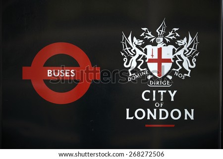 LONDON, UK - APRIL 06: Detail of black City of London banner in bus stop featuring its coat of arms next to the Transport for London red logo. April 06, 2015 in London.