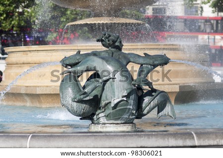 Detail of statue by water fountain in Trafalgar Square, central London, UK