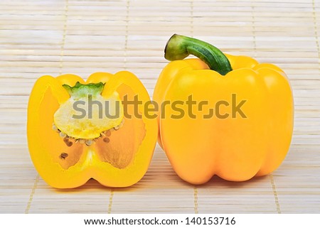 Yellow sweet peppers on bamboo mats.