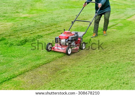 Worker are working with lawn mower.