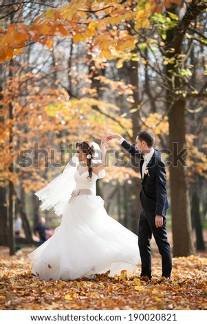 Young wedding couple dance in the park