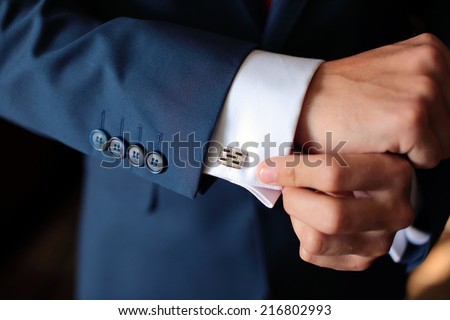 Hands of wedding groom getting ready in suit